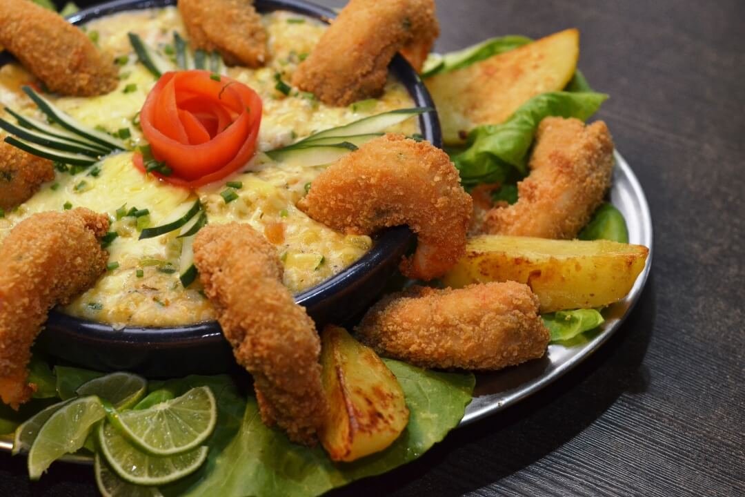 Prato de frutos do mar do Restaurante GuardaGosto na Guarda do Embaú: camarões empanados com creme gratinado e batatas.