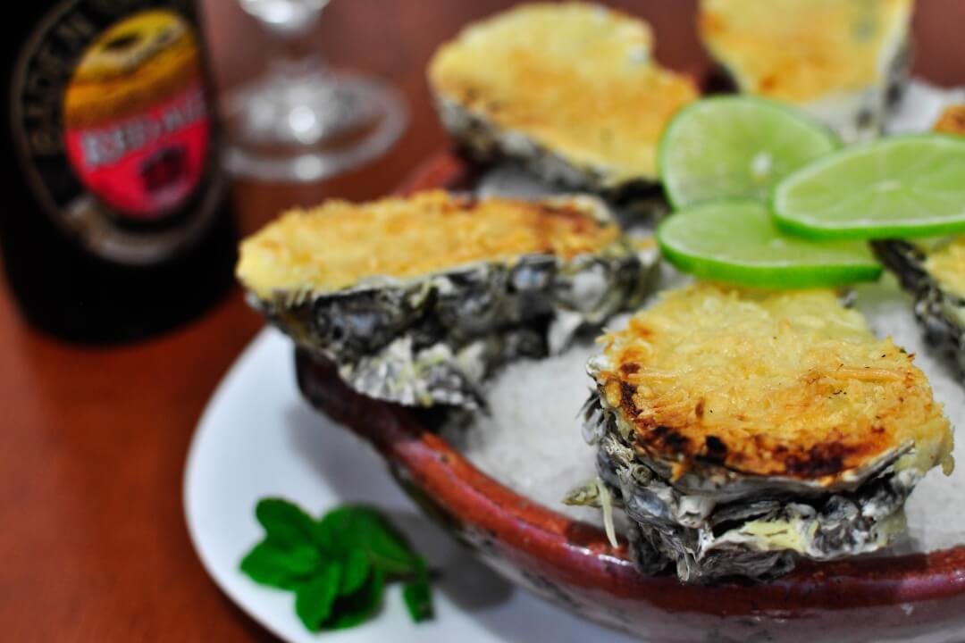 Ostras gratinadas do Restaurante GuardaGosto na Guarda do Embaú, acompanhadas de limão.